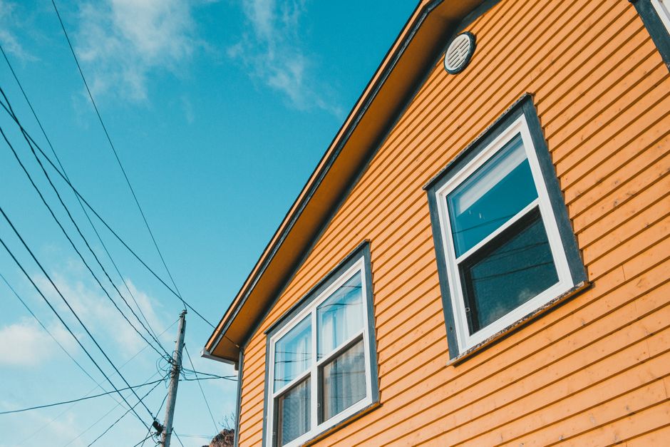 Yellow painted wooden house exterior against a sky
